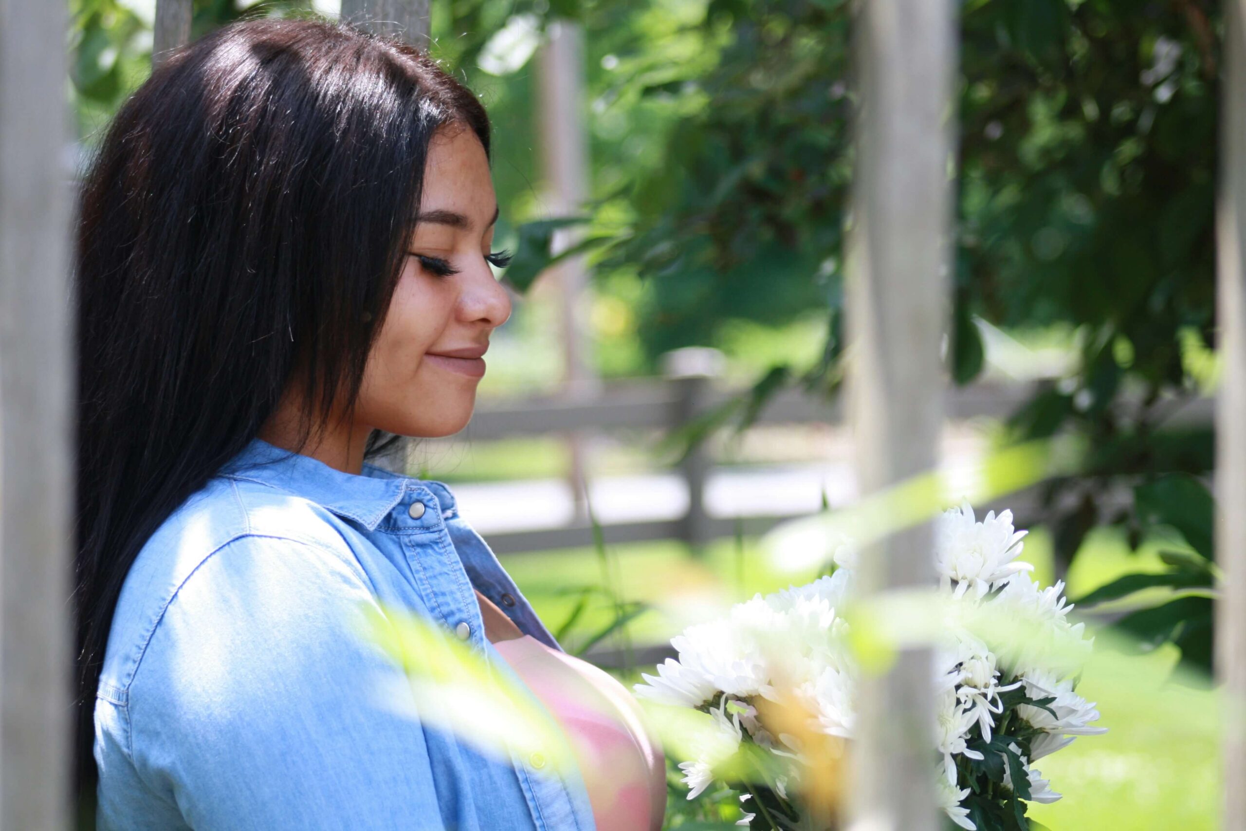 A beautiful black woman holding white flowers. Get started with anxiety counseling in NYC, NY today! Our anxiety therapists can help you with life transitions.