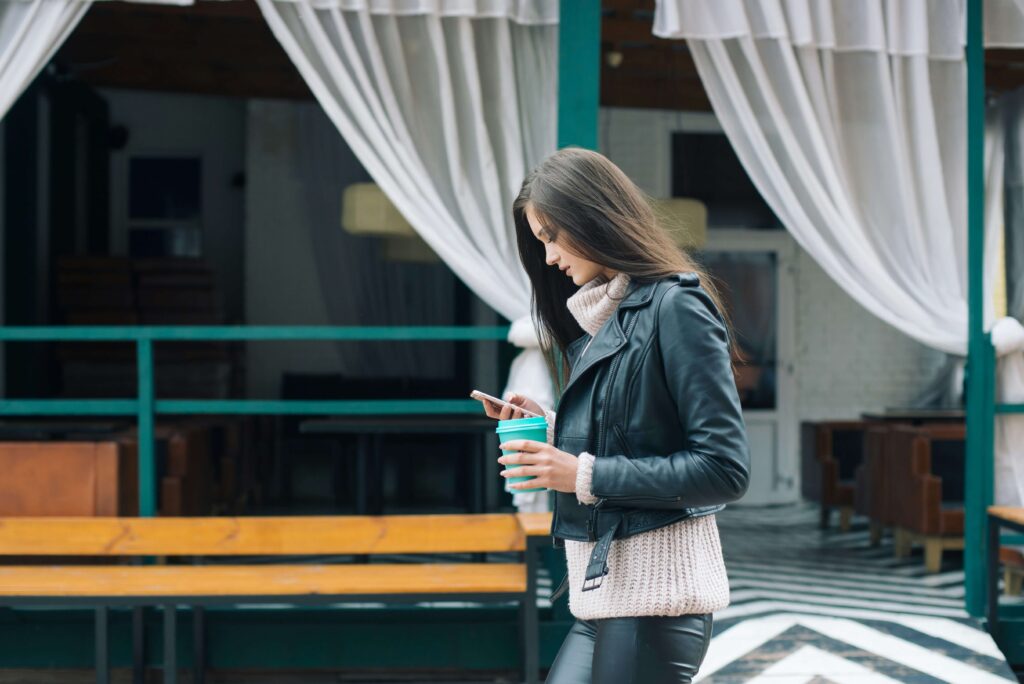 A woman holding a cup of coffee & wearing a leather jacket. Our anxiety counseling in NYC, NY can help you flourish. Our anxiety therapists are here to help. 