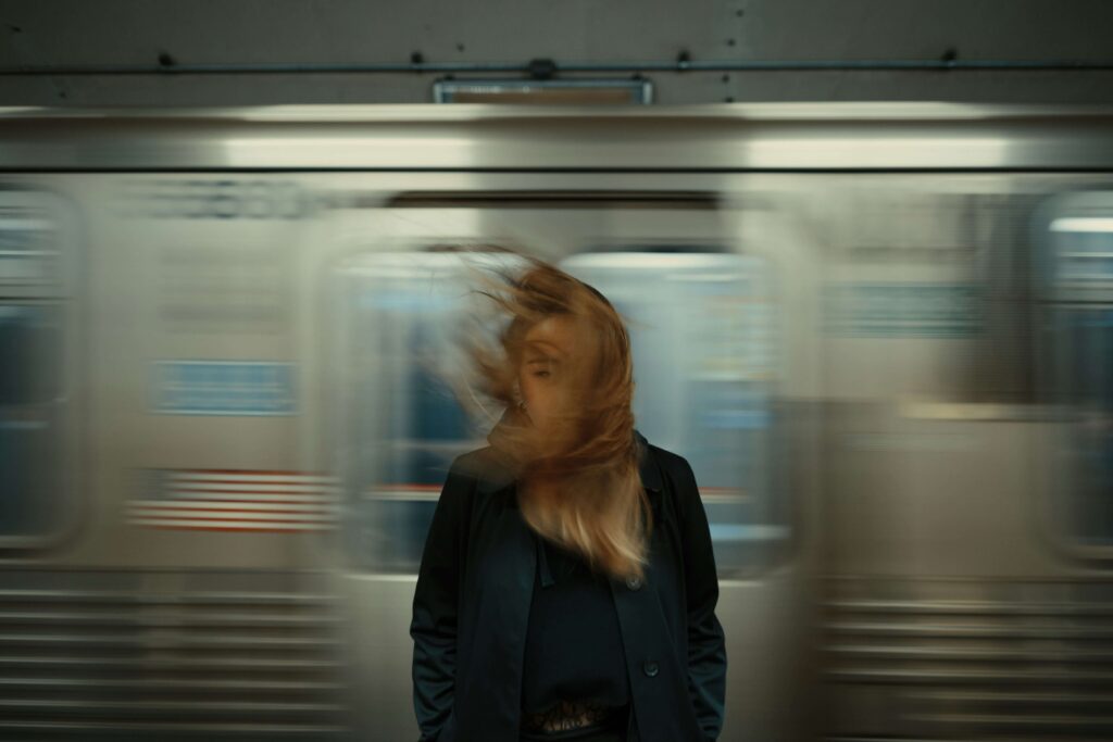 A woman standing in front of the subway. Representing how NYC can feel overwhelming at times. Work with an anxiety therapist in NYC, NY & learn coping strategies!