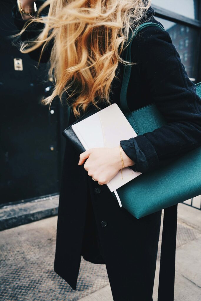 A young woman clutching her journal and book bag. You can feel in control of your body! Learn coping strategies in anxiety counseling in NYC, NY. 
