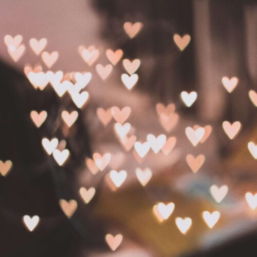 A picture of blurry lights shaped into hearts. If you struggle with anxiety, learn how self-compassion can help alleviate those feelings. Learn more in NYC anxiety counseling.