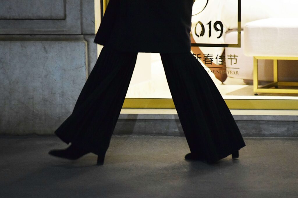 An individual wearing black slacks and black heels walking fast. In the fast paced NYC, work burnout is common. Start working with an anxiety therapist in NYC, NY to combat burnout.