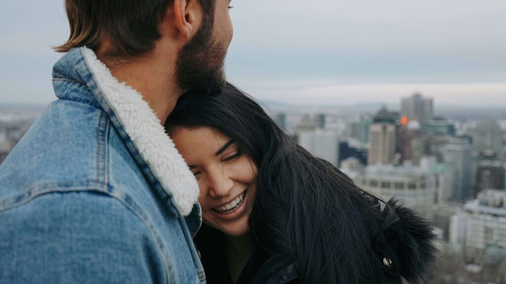 A couple standing close together while smiling. With anxiety therapy in NYC, NY, you can work on retroactive jealousy & relationship issues. Call us today to begin!