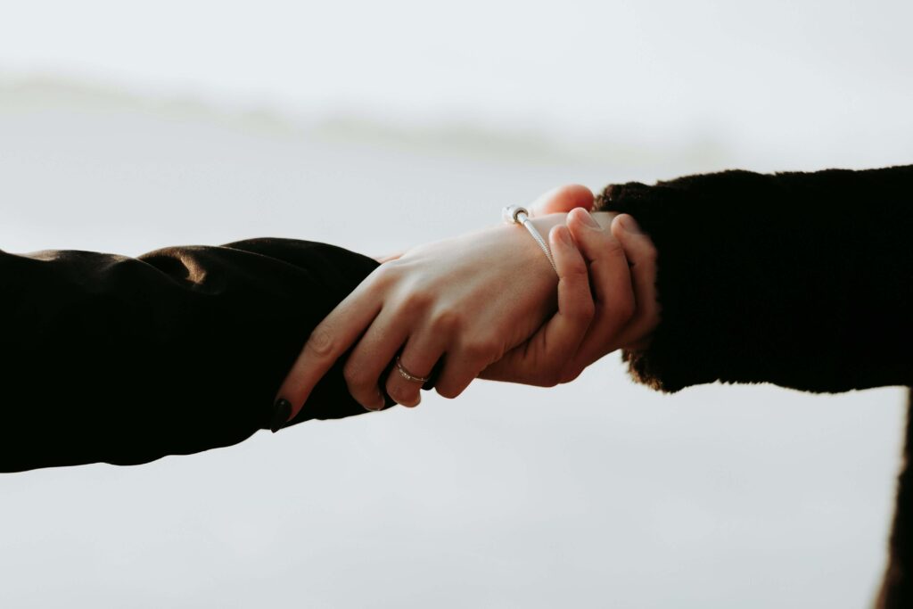 Two individuals holding each other by one arm & reaching out. If you struggle with anxious attachment, consider reaching out to an anxiety therapist in NYC. I offer therapy to help support women like you. 