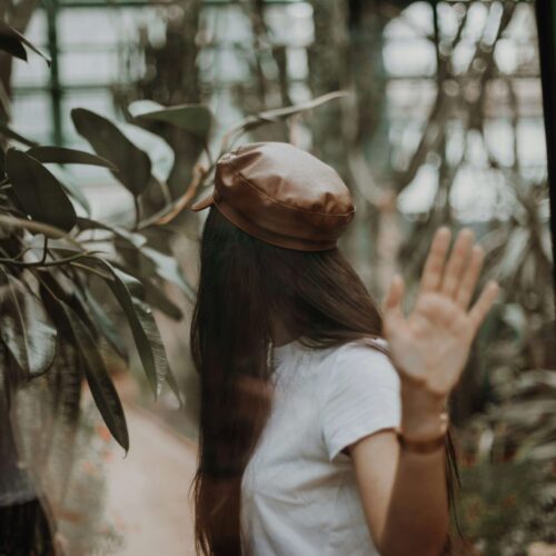 A woman with long brown hair holding her hand to the camera & looking away. Learn why anxiety therapy in NYC, NY can help anxious women thrive. Start your healing journey today with an anxiety therapist.