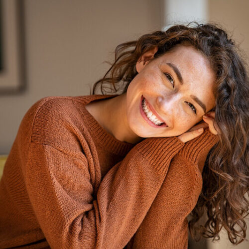 Young woman laughing while relaxing at home