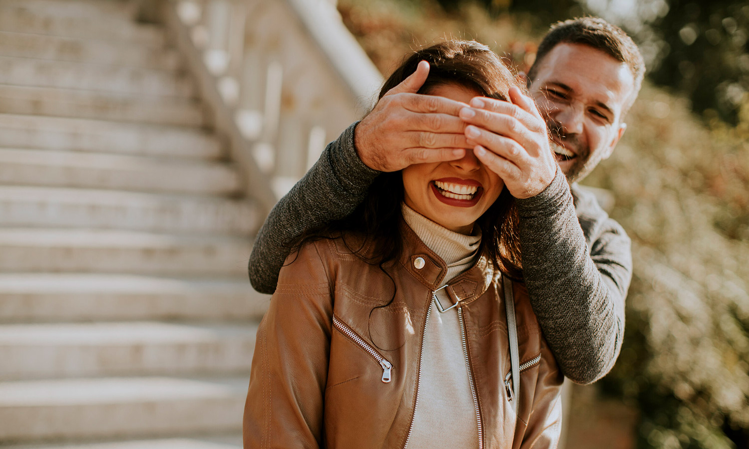 young-man-covering-eyes-his-girlfiend-park