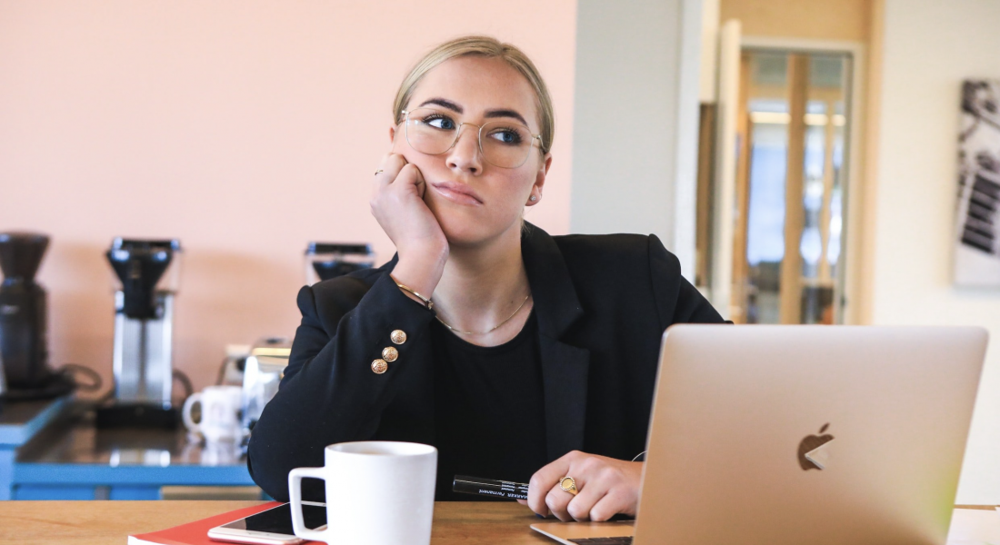 A blonde woman looking off into the distance while she's supposed to be working. If you struggle with procrastination, contact us today to begin our anxiety counseling in NYC, NY. We can help support you to break the procrastination cycle.